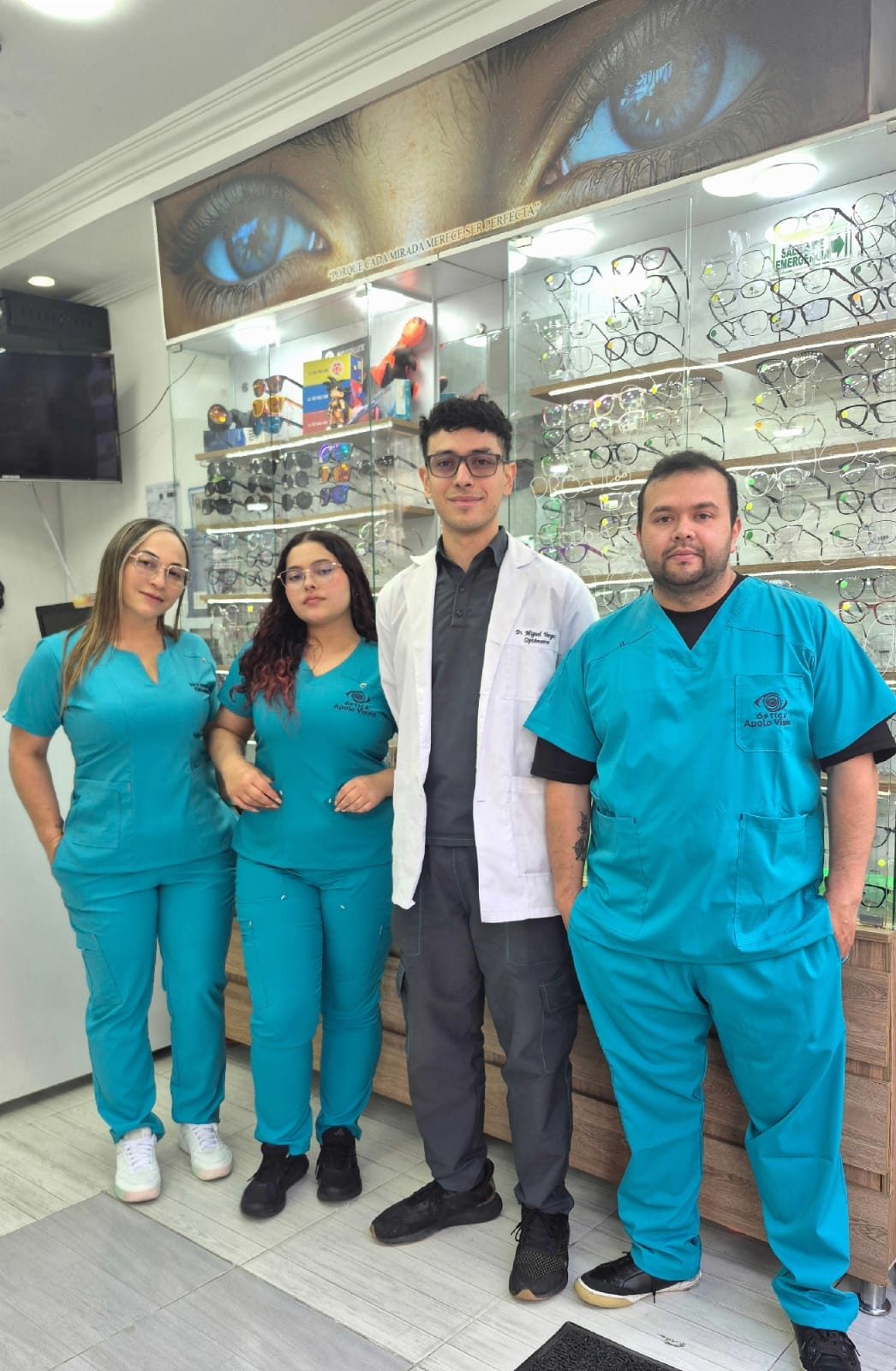 Equipo de Ópticas Apolo Visión en la sede de Bogotá junto a las vitrinas de monturas