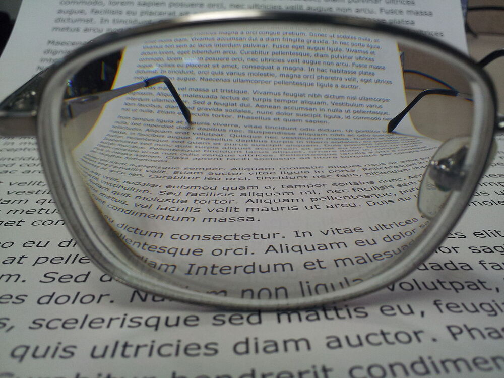 Lente progresivo sobre un texto: la parte inferior aumenta el tamaño de las letras respecto de la superior